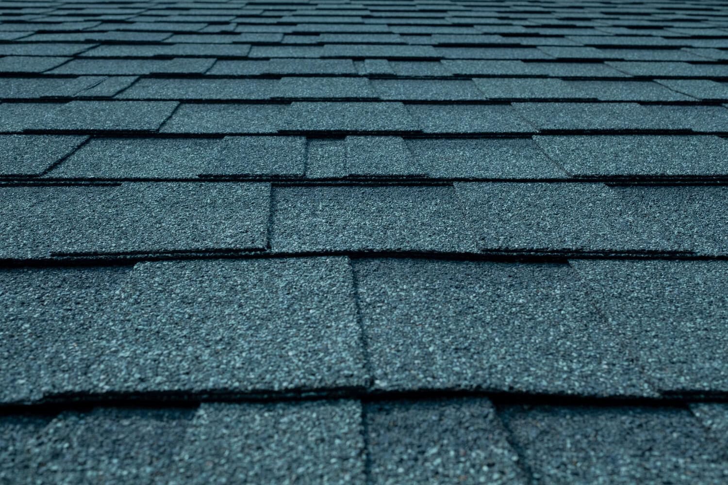 Close-up of asphalt roof shingles, durable roofing materials for residential or commercial roofing services.